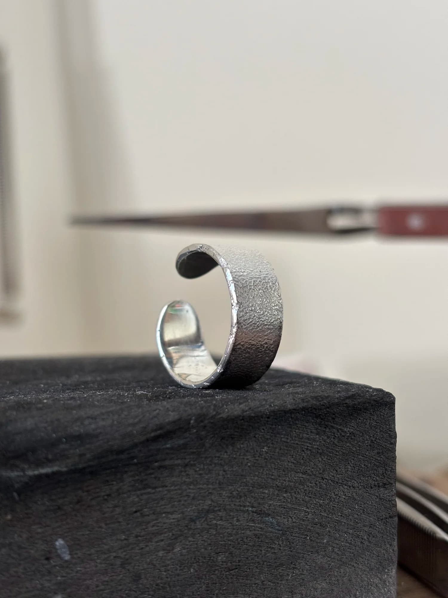 Der breite offene Ring von der Seite, die matte, feinkörnige Struktur der gewalzten Oberfläche gut sichtbar.
