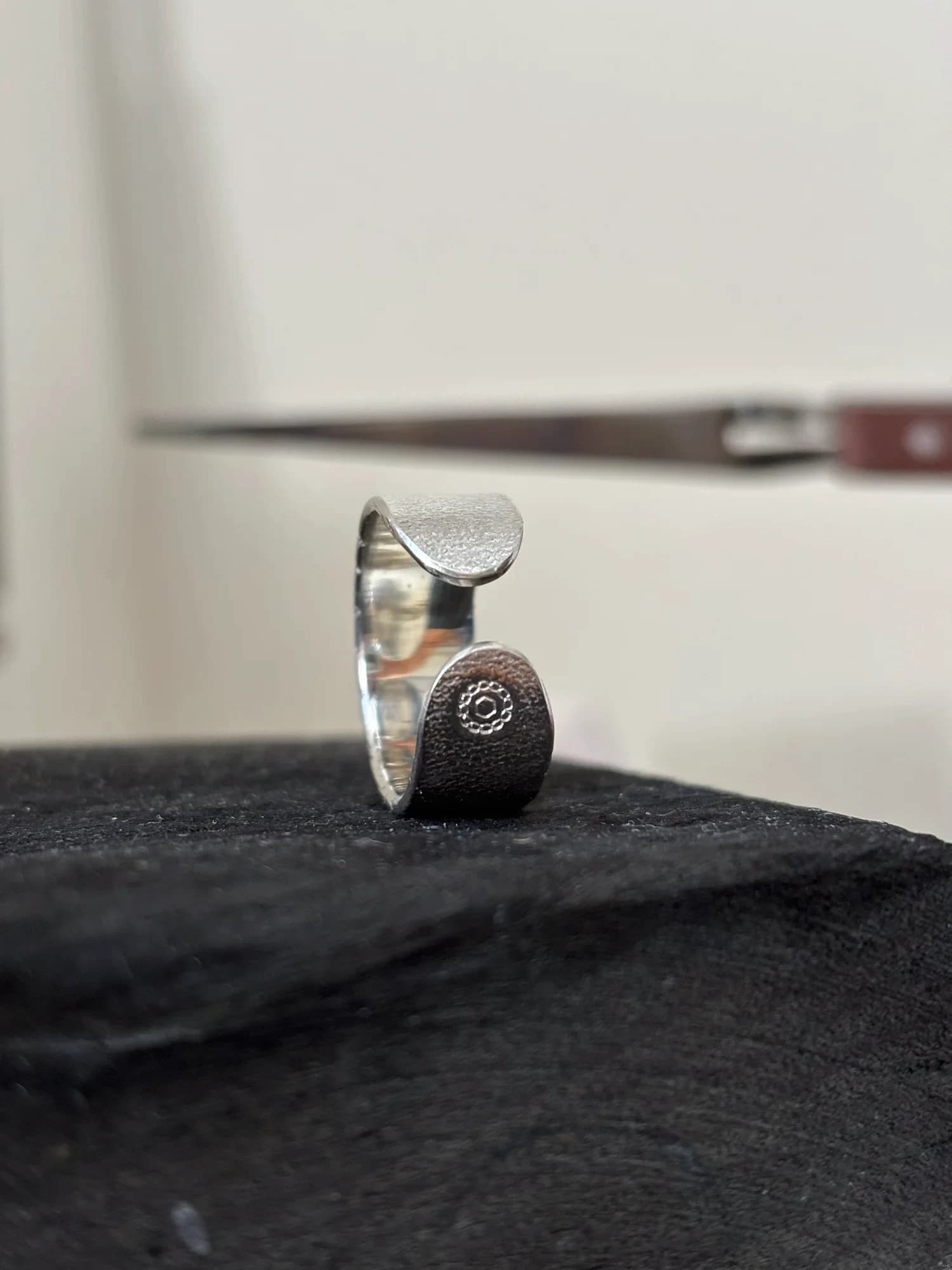 Nahaufnahme der beiden runden Enden des Rings, eines mit der eingeprägten MADU JIWA-Punze.