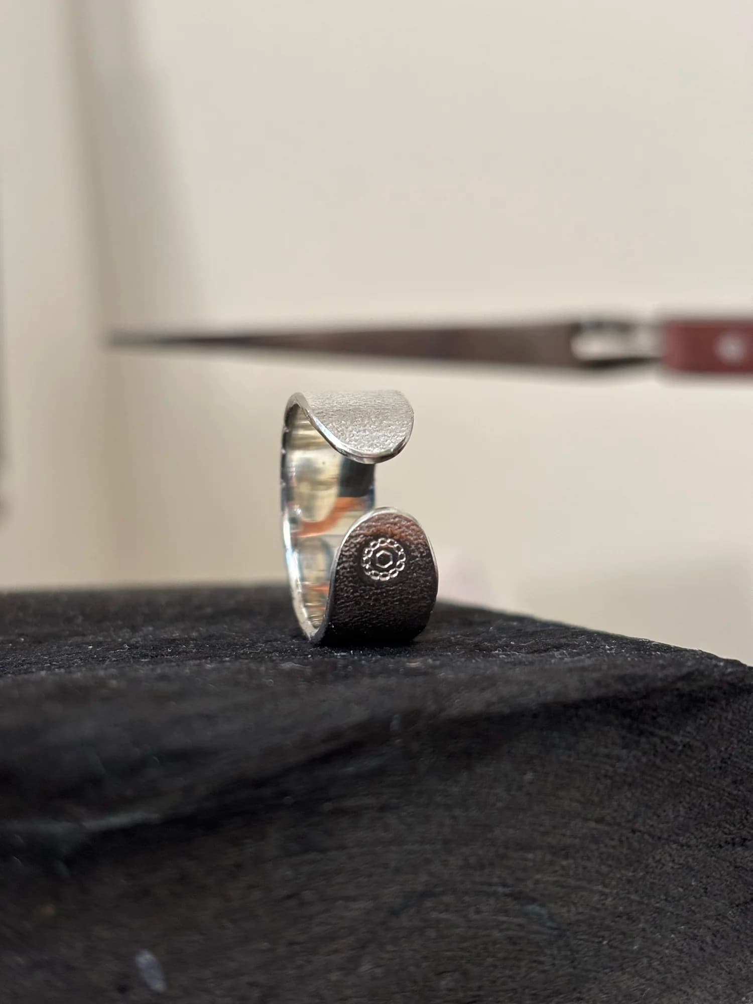 Nahaufnahme der beiden runden Enden des Rings, eines mit der eingeprägten MADU JIWA-Punze.
