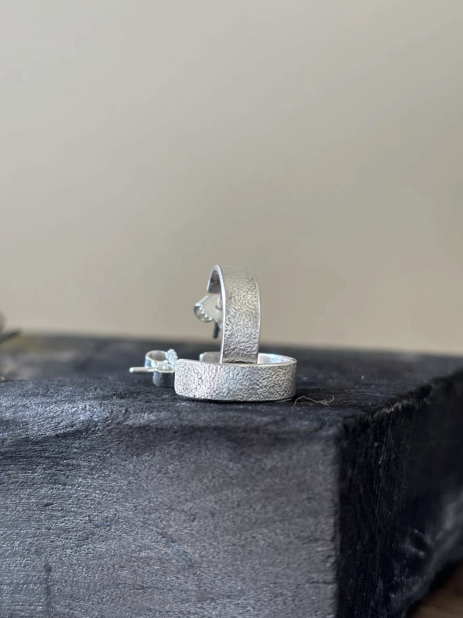 Seitliche Detailansicht der offenen Silber-Creolen mit Stecker und feiner Textur.