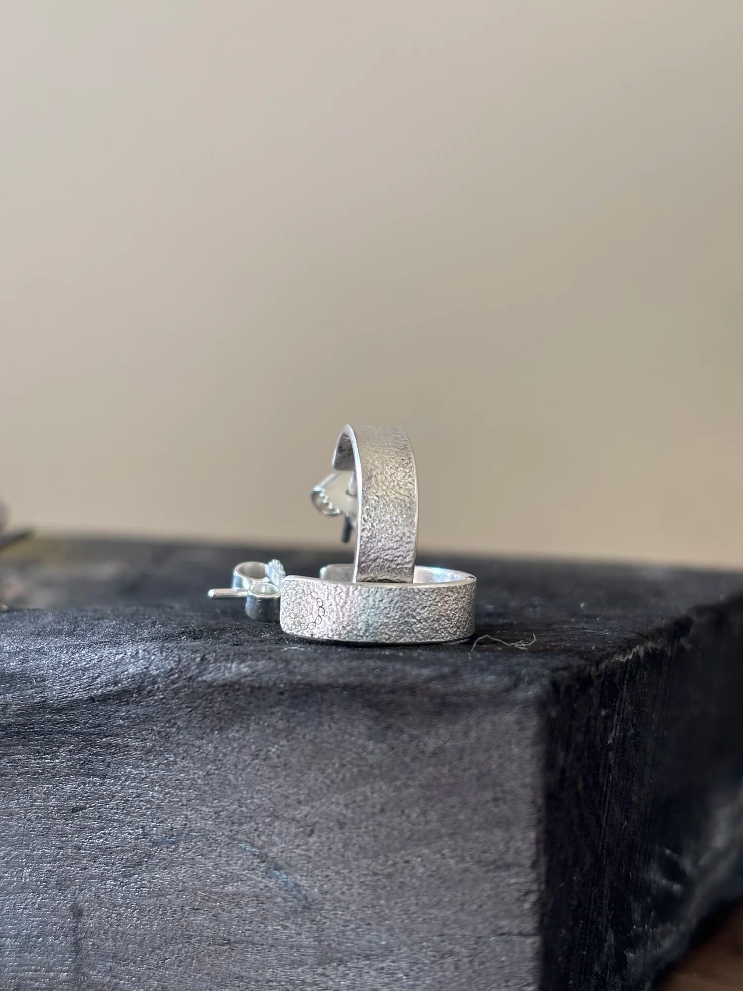 Seitliche Detailansicht der offenen Silber-Creolen mit Stecker und feiner Textur.